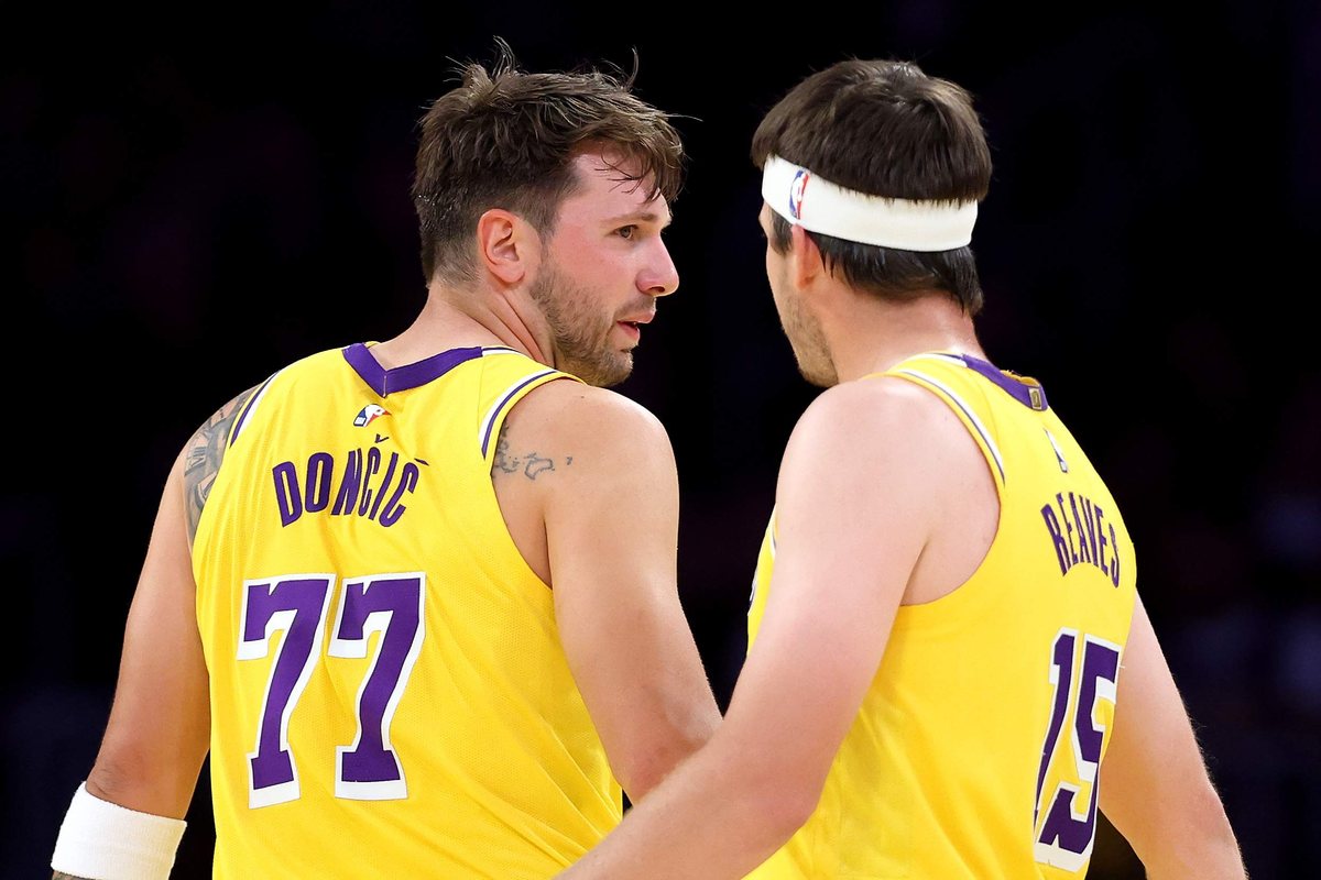 Luka Doncic and Austin Reaves stand together in gold Lakers uniforms.