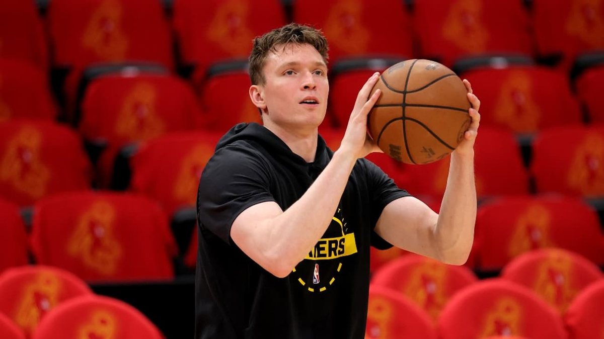 Dalton Knecht holds a basketball while wearing a black Lakers warmup shirt.