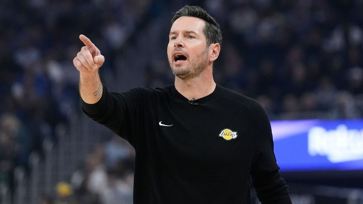 JJ Redick points across the court while wearing a black Lakers shirt.