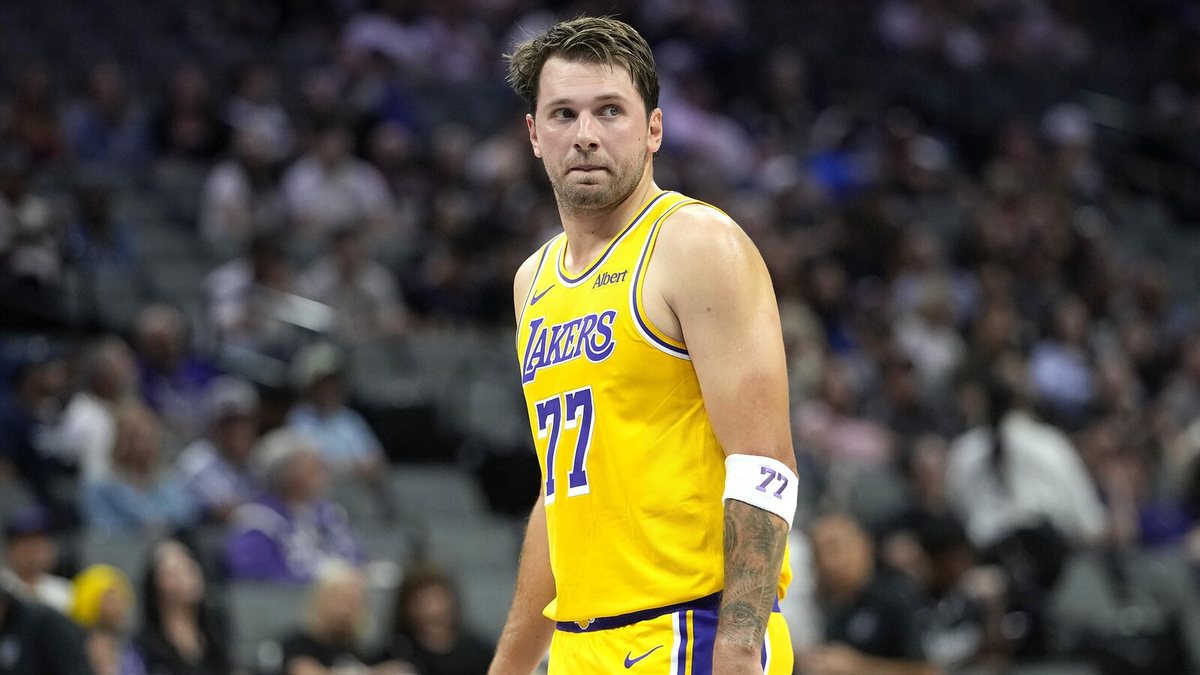 Luka Doncic looks across the floor in a gold Lakers jersey.