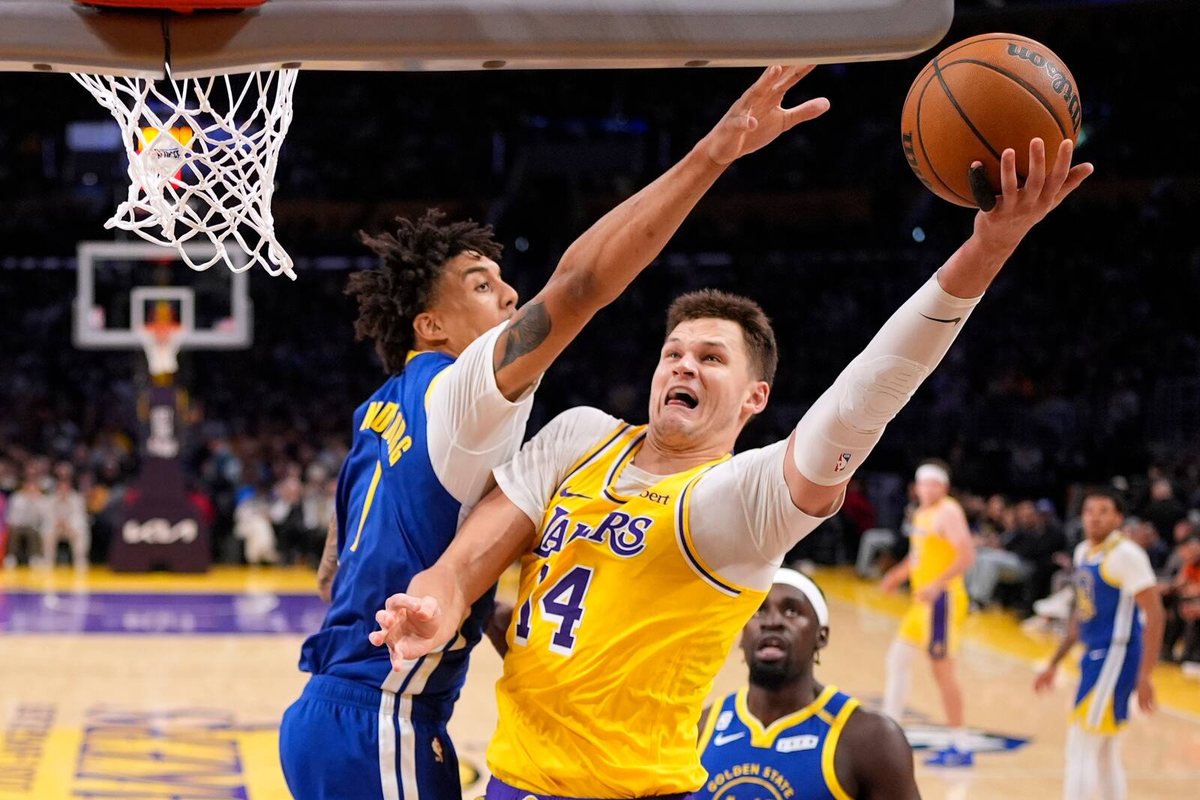 Walker Kessler shoots with Yaxel Lendeborg contesting at the rim.