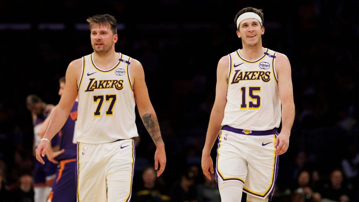 Luka Doncic and Austin Reaves, both in white Lakers jerseys, walk down the court during a game.