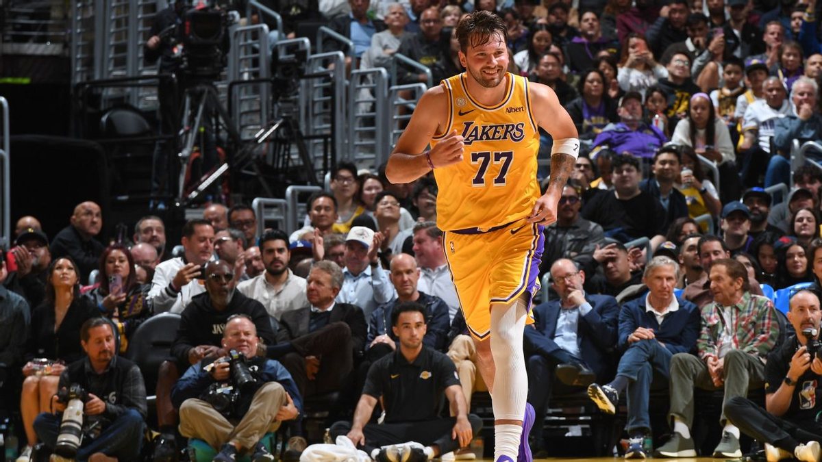 Luka Doncic runs up the court wearing a gold No. 77 Lakers uniform.