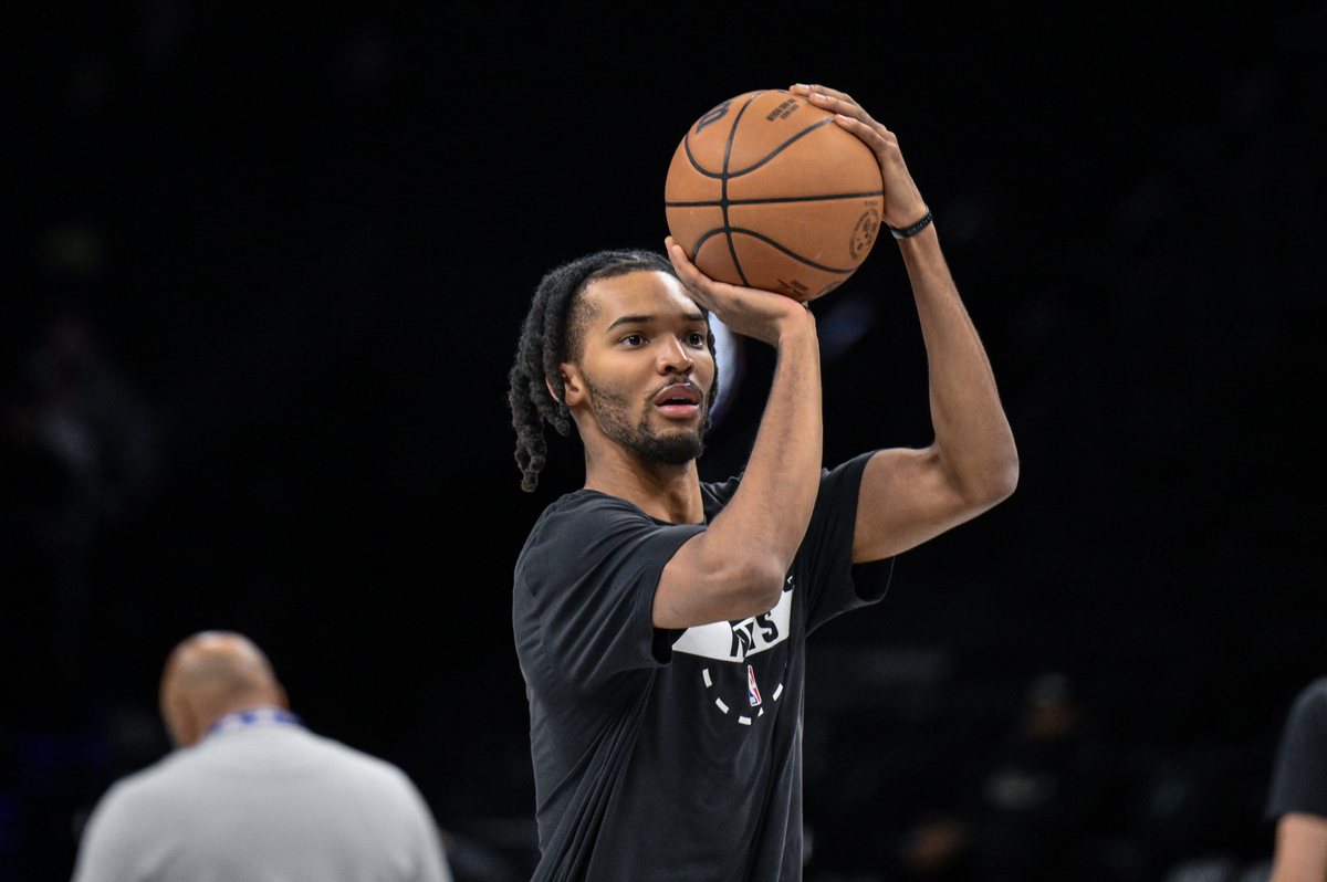 Ziaire Williams prepares to shoot while wearing a black Nets warmup shirt.